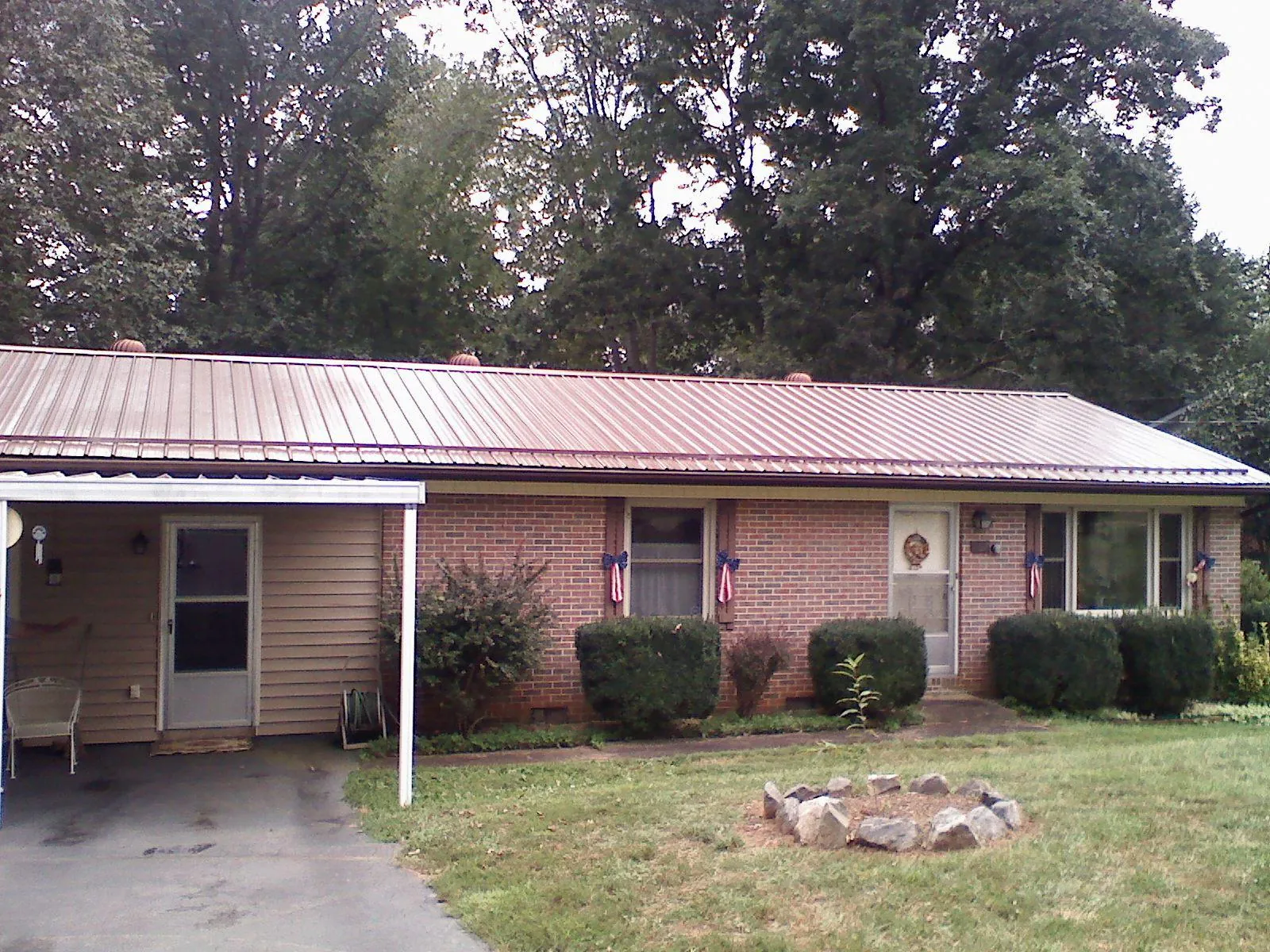 Bronze metal roof and carport on a brick ranch home — Roof Repair work by our crew in Lake Wilson